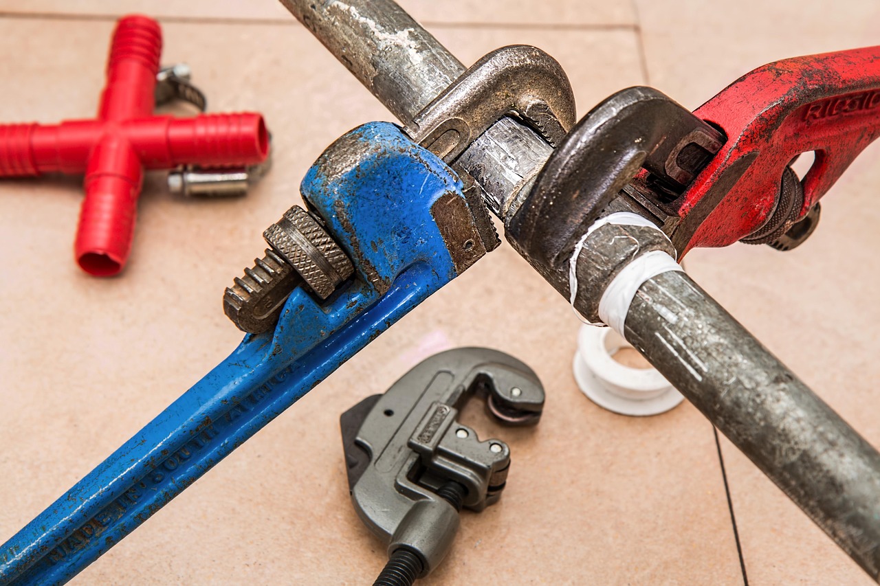Plumber using professional tools during a home renovation repair
